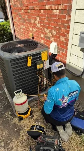Technician servicing an outdoor residential air conditioner with gauges